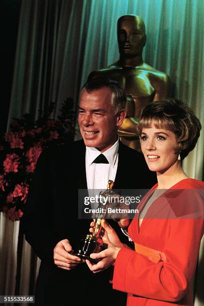 Actor Lee Marvin holds the Oscar presented to him by Julie Andrews for the best performance by an actor at the 1966 Academy Awards presentation...
