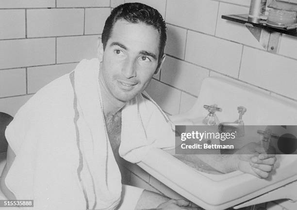 Pittsburgh, Pennsylvania: Sandy Koufax bathes his arm in ice water after he pitched a seven-hitter and took over the National League Strikeout lead...