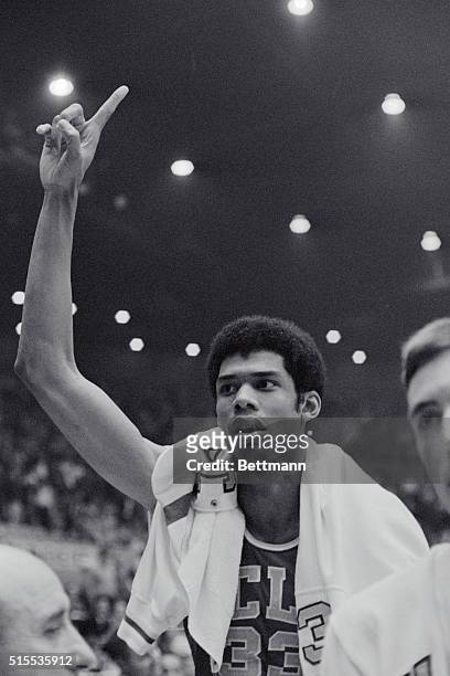 Center Lew Alcindor, prior to his 1971 name change to Kareem Abdul-Jabbar, acknowledges cheering teammates and fans following the Bruins' victory...