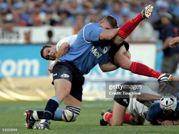Rassie Erasmus of the Cheetahs is tackled by Kees Lensing of the Bulls during the ABSA Currie Cup Final between the Blue Bulls and the Cheetahs at...