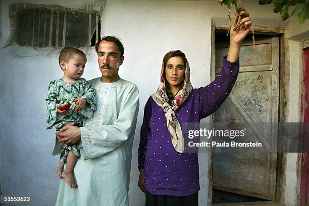 Mariam, 20-years-old and 9 months pregnant, stands next her husband Mohammed who is holding their daughter Sharara, 2-years-old, October 22, 2004 in...