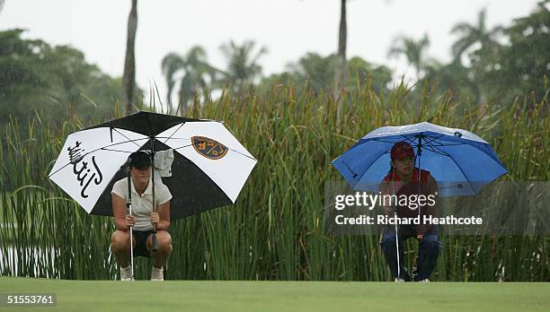 Karin Sjodin of Sweden and Jane Park of the USA line putts up underneath their umbrella's during the final round of the Espirito Santo trophy, The...