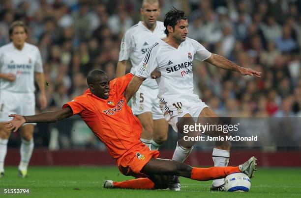 Luis Figo of Real Madrid is tackled by Sissoko of Valencia during the La Liga match between Real Madrid v Valencia at the Bernabau stadium on October...