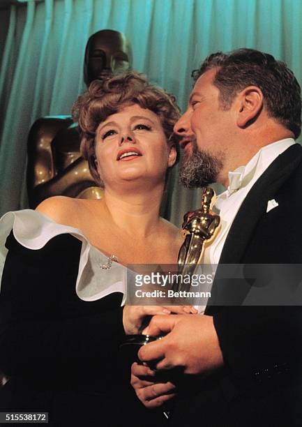 American actress Shelley Winters holds the Oscar presented to her by Peter Ustinov for best performance by an actress in a supporting role for her...