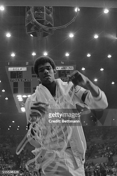 Los Angeles, California: UCLA's Lew Alcindor pulls down the net as a trophy after the UCLA Bruins won the NCAA finals by defeating North Carolina...