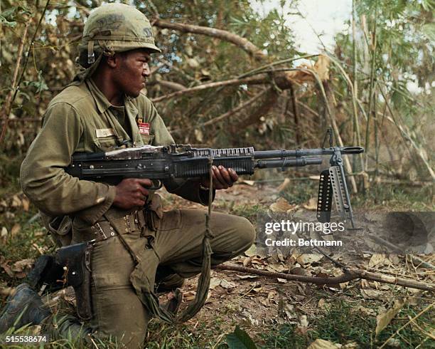 Private First Class Milton L. Cook fires his M-60 machine gun into a wooded area from which sniper fire had been received 10 miles northeast of Cu...