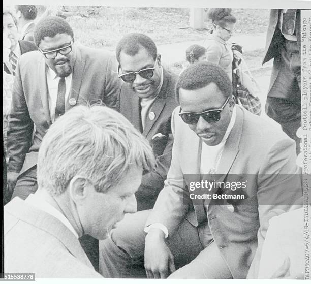 Professional football players from the Chicago Bears and Los Angeles Rams huddle with Sen. Robert Kennedy as the Kennedy primary election team tours...
