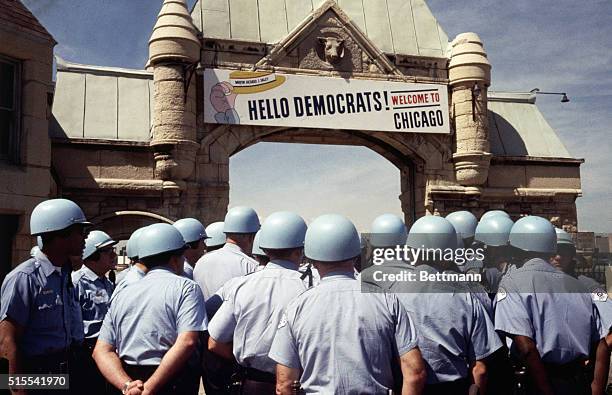 The sign over the archway leading to the International Amphitheater welcomes delegates to the Democratic Convention, but from the sea of police...