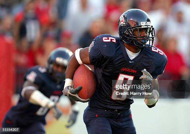 Antoine Cason of Arizona makes an interception off of a deflection by Wilrey Fontenot in the second quarter at Arizona Stadium on October 23, 2004 in...