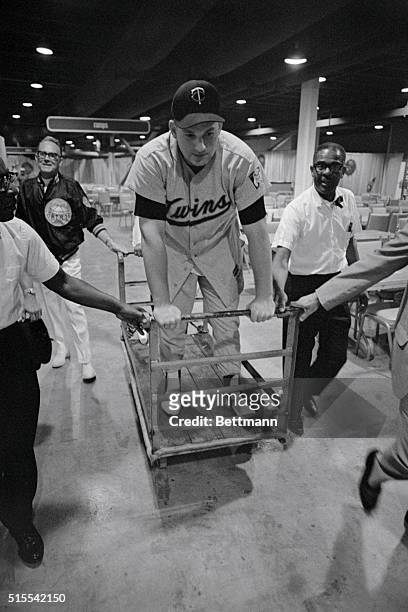 Houston: Harmon Killebrew, first baseman for the American League's Minnesota Twins, is removed from the dugout to the clubhouse on a cart after he...