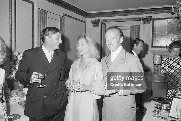 Actor David Niven, , chats with actress Lauren Bacall and author and magazine publisher William Buckley during a reception following the wedding of...