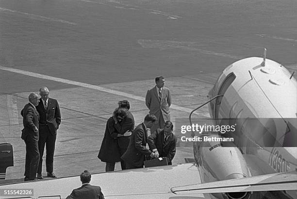 Mrs. John F. Kennedy is comforted by Burke Marshall, IBM Vice President and former U.S. Assistant attorney general, at Kennedy Airport here June 5th....