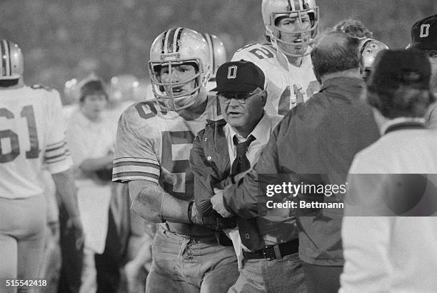 Ohio State Coach Woody Hayes is restrained by his own player, Ken Fritz and an assistant coach after the game erupted into a slug fest following a...