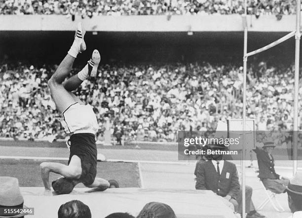 Richard Fosbury of Medford, Oregon, lands on his head here after clearing 7 feet 2 3/4 inches in the high jump. Fosbury who slides over the crossbar...