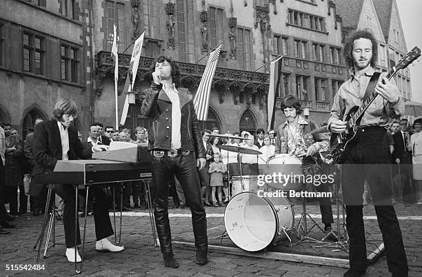 This is a photo of the American rock group, "The Doors," performing outside of Town Hall in Frankfurt. Left to right are organist Ray Manzarrek; lead...