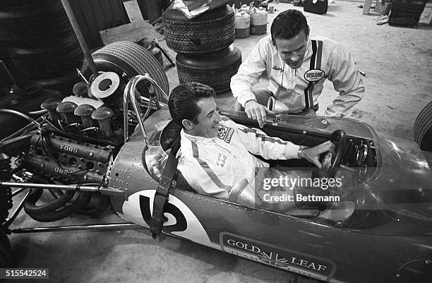 Indy 500 winner Bobby Unser and fellow oval track driver Mario Andretti compare notes before making their Formula One racing debut in practice for...