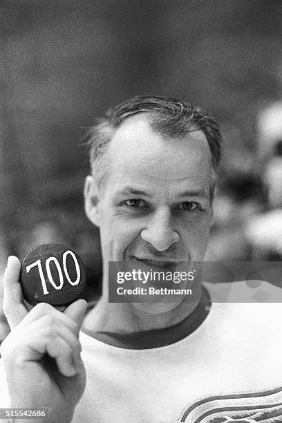 Gordie Howe smiles for photographers and displays the puck he slammed into the Penguin net for his 700th career goal here, 12/4. The Red Wings beat...