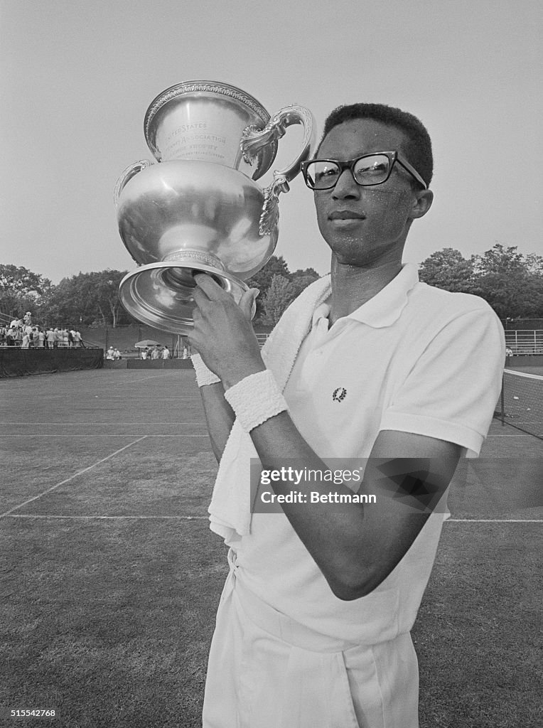 Arthur Ashe Holding Trophy