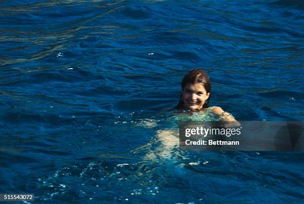 Ten days after her wedding to shipping tycoon Aristotle Onassis, the former Jackie Kennedy swims in the blue water alongside her husband's yacht...