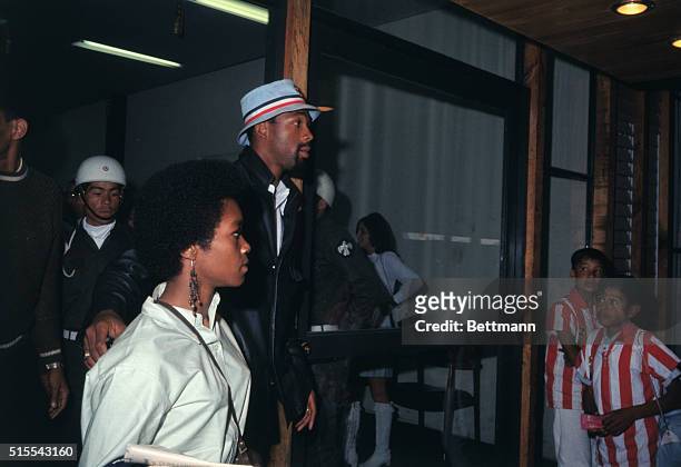 Mexico City, Mexico: Suspended U.S. Olympic star John Carlos and his wife are shown as they leave Olympic Village after the U.S. Olympic Committee's...