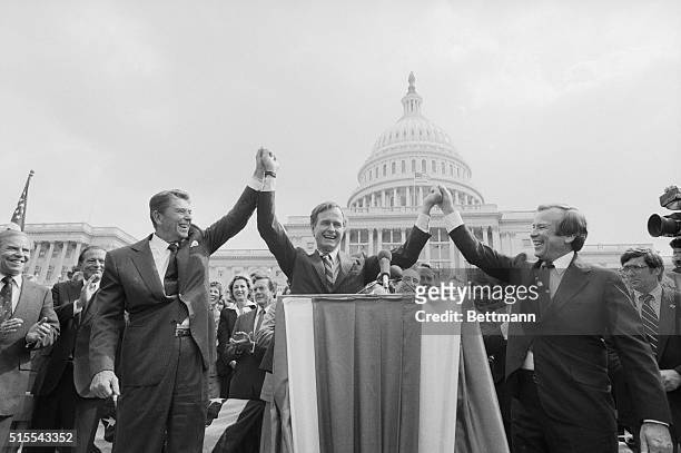 Washington: GOP Presidential candidate Ronald Reagan locks hands with running mate George Bush and Senate Minority Leader Howard Baker during a rally...