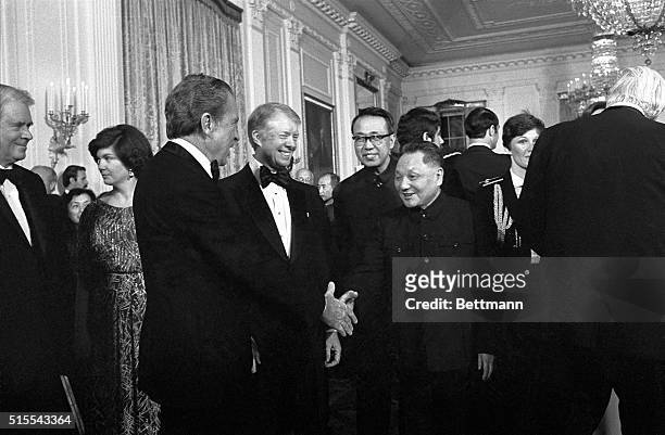 Washington, DC- As President Jimmy Carter looks on, former President, Richard Nixon, reaches out to shake hands with Chinese Vice Premier, Teng...