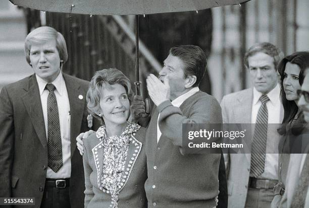 Washington: President Reagan blows a kiss to White House staffers assembled on the South Lawn 4/11, as wife Nancy looks on. Reagan was greeted by a...