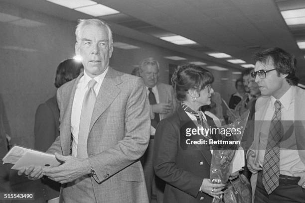 Los Angeles: Michelle Triola Marvin, holding a single rose is ignored by her former lover, Lee Marvin, as they return to Superior Court after a lunch...