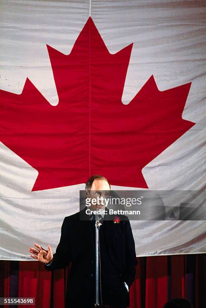 The Prime Minister of Canada , Pierre Elliott Trudeau is shown standing in front of Canadian flag.