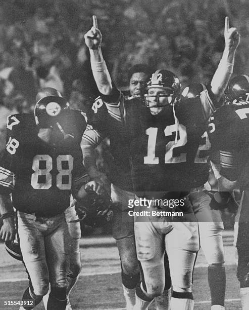 Miami: Steelers quarterback Terry Bradshaw holds up number one fingers as he and his receiver Lynn Swann walks off the field of Super Bowl XIII in...