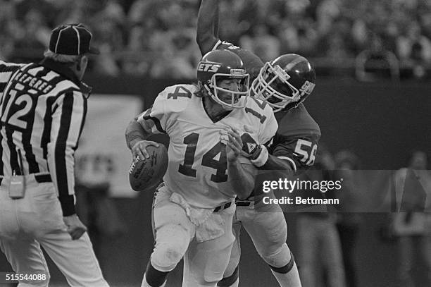 New York Giant's Lawrence Taylor gets his hands on Jets quarterback Richard Todd pulling him down during the fourth quarter of play here at Giant...
