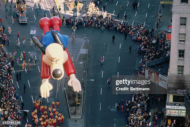 The float of the cartoon character "Underdog" hovers over the crowd gathered to watch the annual Thanksgiving Day Parade in New York City.