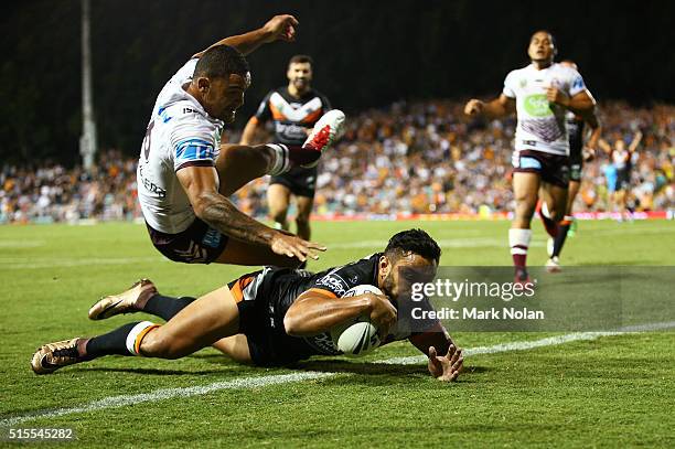 Dylan Walker of the Eagles attempts to prevent David Nofoaluma of the Tigers from scoring a try during the round two NRL match between the Wests...