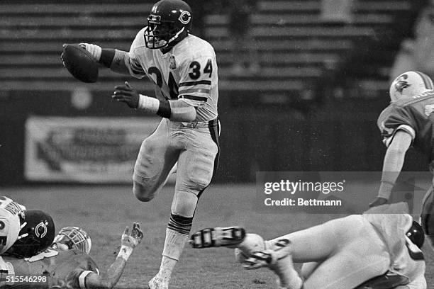 Chicago Bears halfback Walter Payton dances through an opening in the Buccaneers line as he advances for several yards during the first half of their...