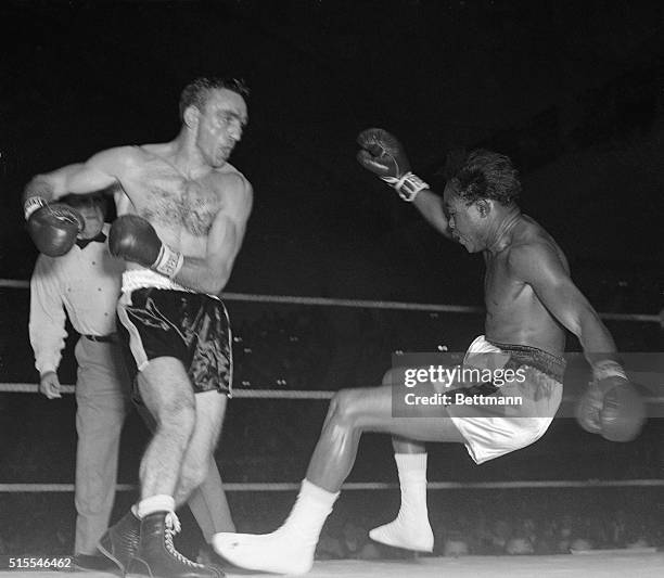 Left hook by contender Carmen Basilio sends Welterweight Champion Kid Gavilan to the canvas in the second round of their title go in Syracuse . The...