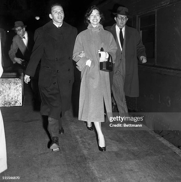 In No Crooning Mood. Arriving from Philadelphia, where yesterday they applied for marriage license, Ava Gardner beams as she strides from train with...