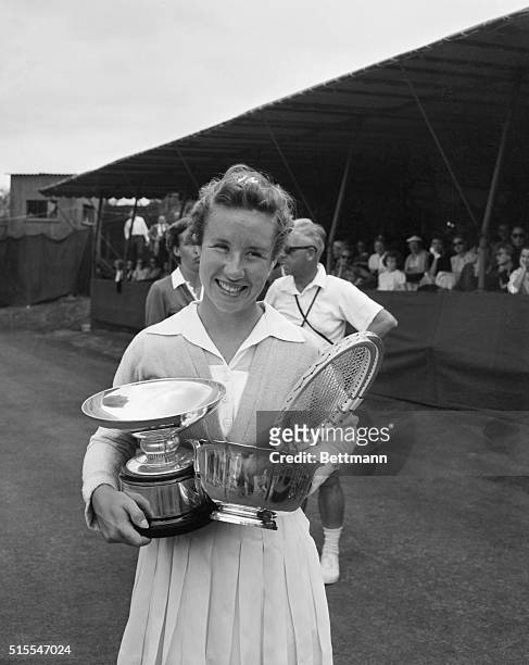 Forest Hills,NY: Her arms filled with trophies to add to her growing collection, tennis star Maureen Connolly smiles happily after retaining her...