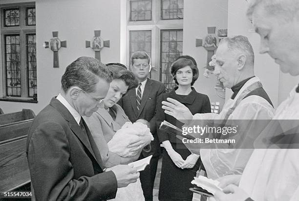 John F. Kennedy, Jr., infant son of President-elect John F. Kennedy, is christened in the chapel of Georgetown Hospital. At the left are Mr. And Mrs....