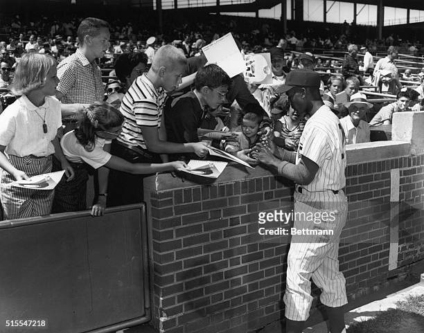 Chicago Cubs shortstop Ernie Banks signs autographs at Wrigley Field in Chicago. Banks would go on to win the Most Valuable Player award in the 1958...