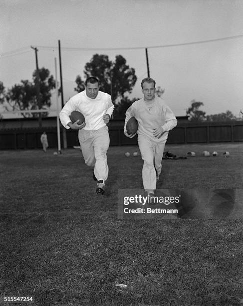 Jim Taylor and Paul Hornung, in sweat togs as they work out at Stanford University practice field 12/13. The two 215 pounders give the Green Bay...