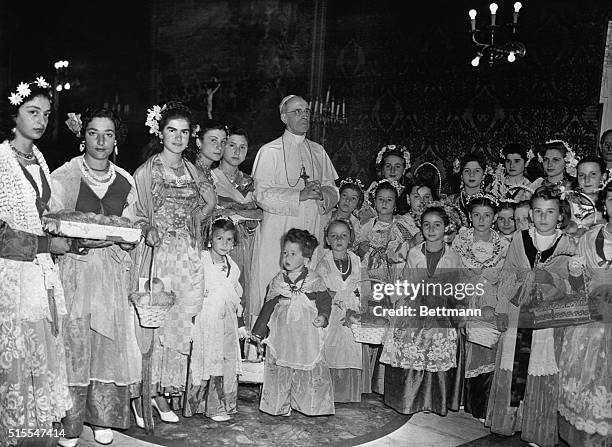 Pope Pius XII poses with a group of girls, clad in traditional costumes of Castelgandolfo, when they called at his summer palace to present him with...