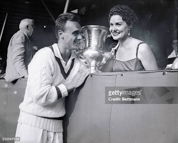 Vic Seixas, 1953 Wimbledon champ, is shown with his wife and trophy after winning the U.S. Amateur Tennis Crown today. Going to bat for the third...