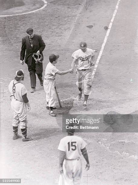 Gil Hodges is shown crossing the plate after hitting his 200th homer in the fifth inning of today's game with the Giants. Umpire Gorman and Giant...