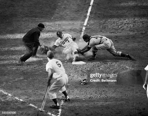 Peewee Reese of the Dodgers slides into home beating the peg to Cub catcher fanning in the fifth inning of the nightcap of a twin bill. Reese scored...