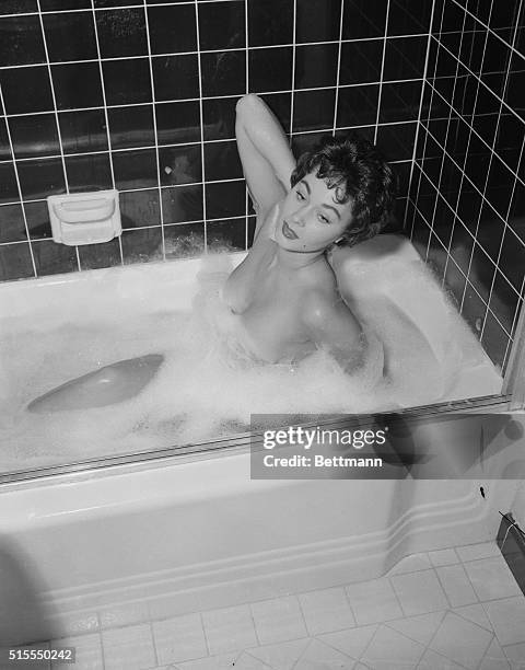 All this starts when pretty Marla English, film starlet, scrubs her shapely legs and soaps her comely back-- as she gets ready to attend a Hollywood...