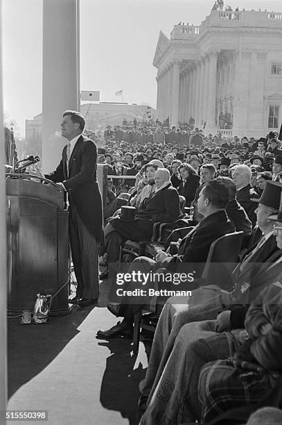 President John Kennedy gives his inaugural address. Directly behind him are his wife Jackie Kennedy, and outgoing President Dwight Eisenhower.