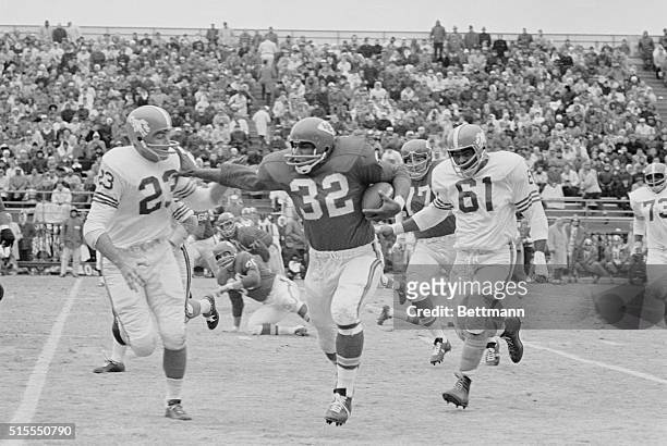 Kansas City Chiefs running back Curtis McClinton carries the ball on his way to a first down in a 1963 game against the Denver Broncos. Pursuing...