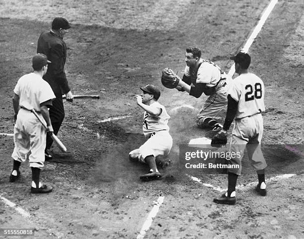 The umpire appears to have the undivided attention of all concerned in this second inning action in today's game between the National League champion...