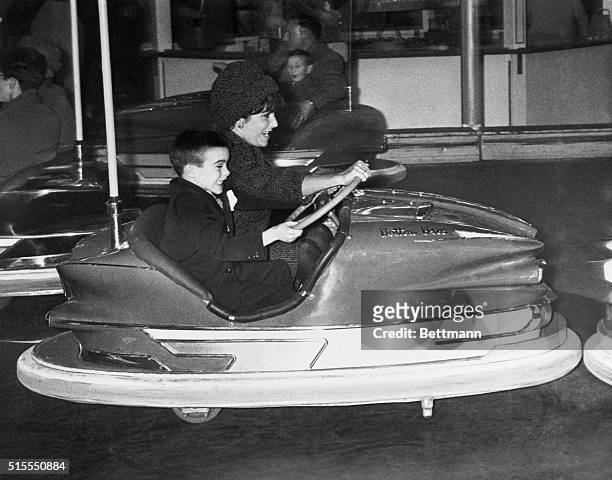 Miss Taylor and her son, Michael, both grit their teeth in mock anger as they wheel around in an electric bumper-car in the circus rides area.