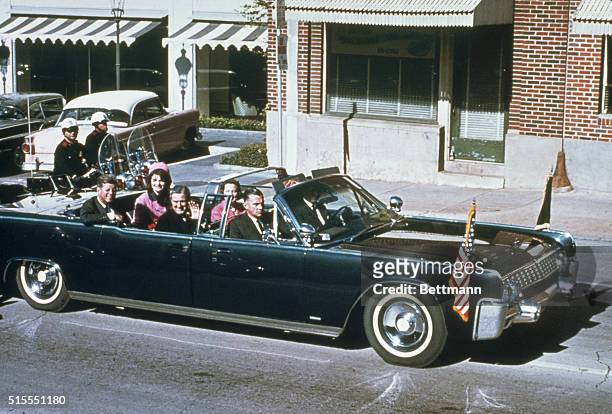 President John F Kennedy, First Lady Jacqueline Kennedy, Texas Governor John Connally and his wife Nellie Connally ride together in a convertible...